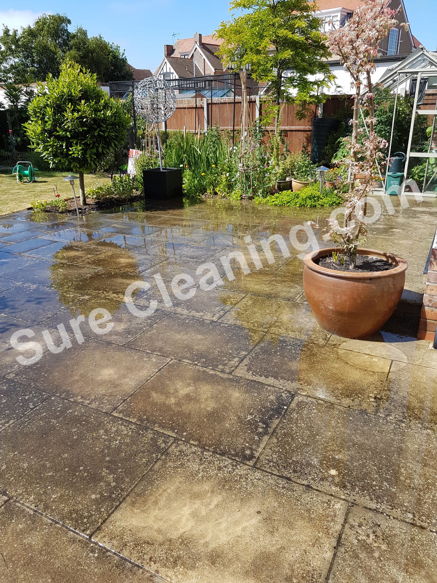 Patio with black spot before being pressure cleaned